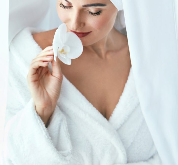 Beauty Spa Salon. Woman In Towel After Body Skin Care With Orchid Flower. High Resolution